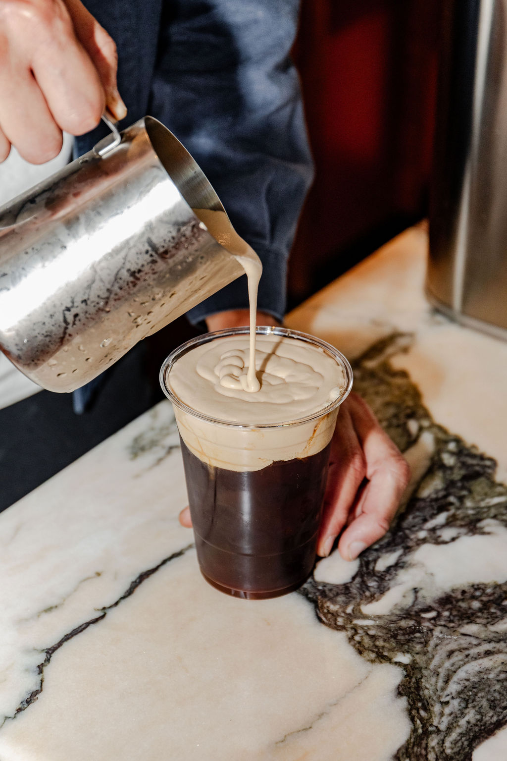 Cold brew with corn husk foam being poured