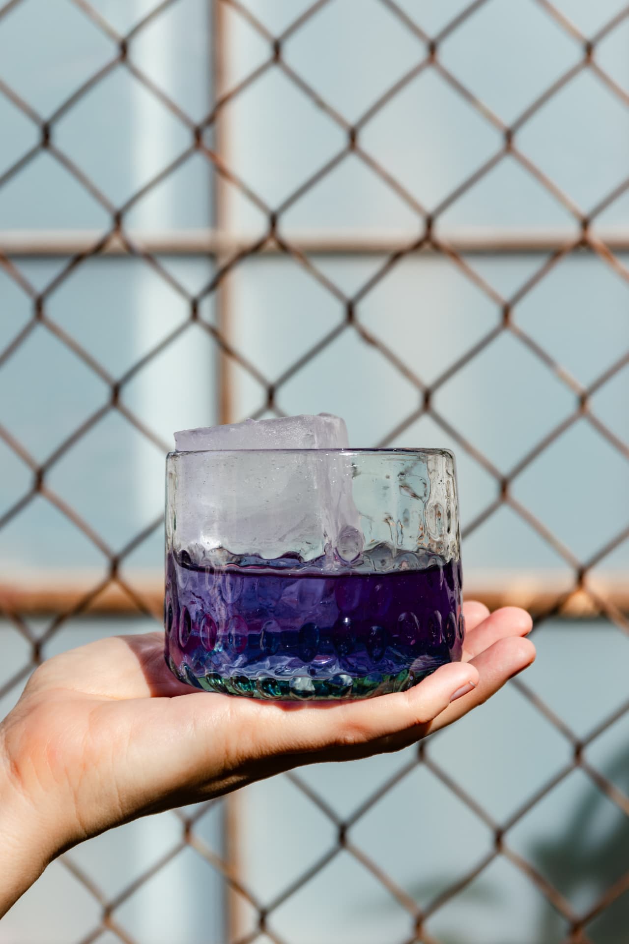 Purple cocktail in hand-blown glass