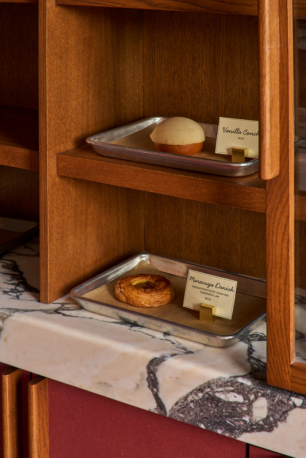 Pastries on trays in the oak case