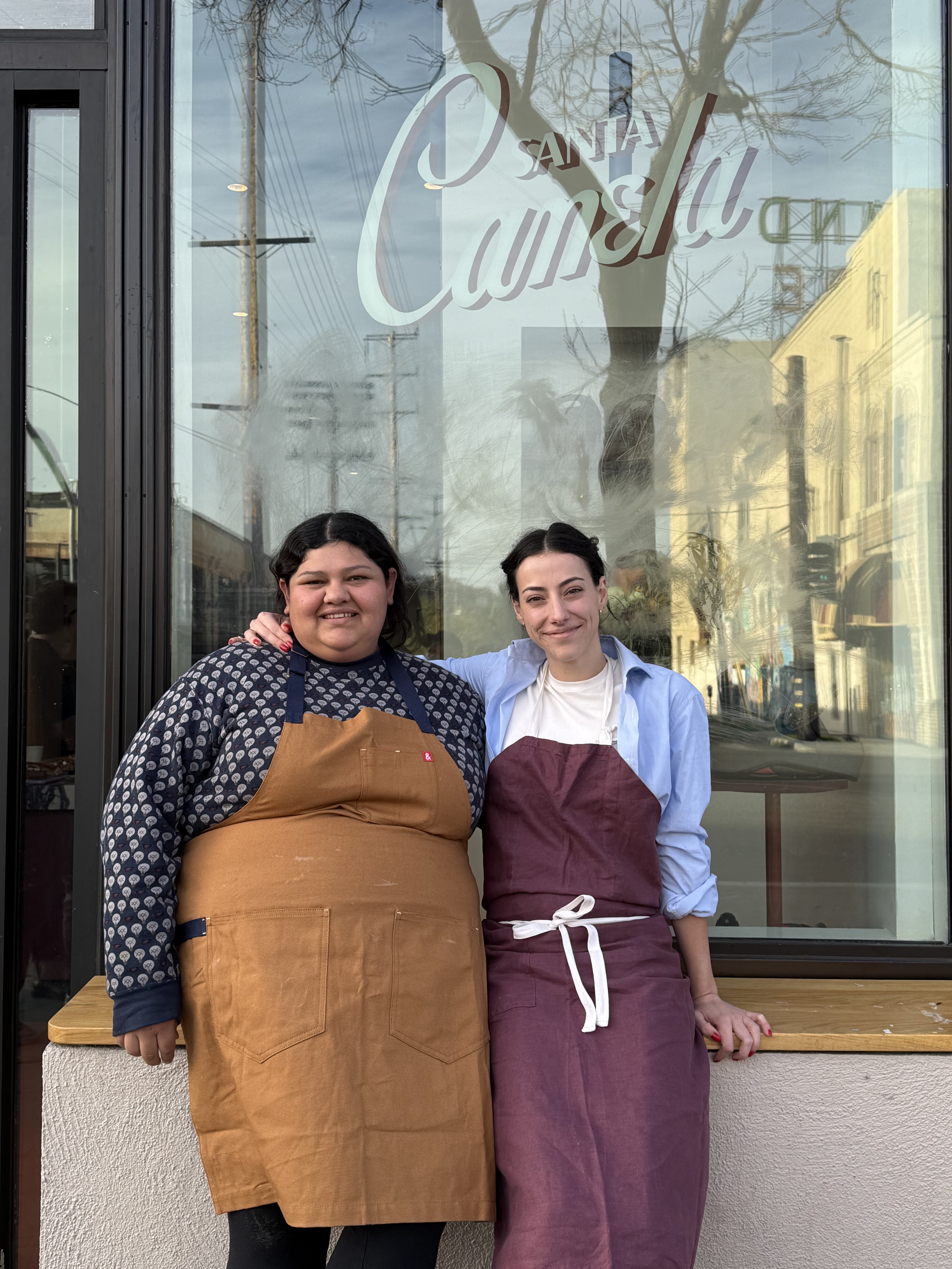 Two Santa Canela team members outside the bakery window