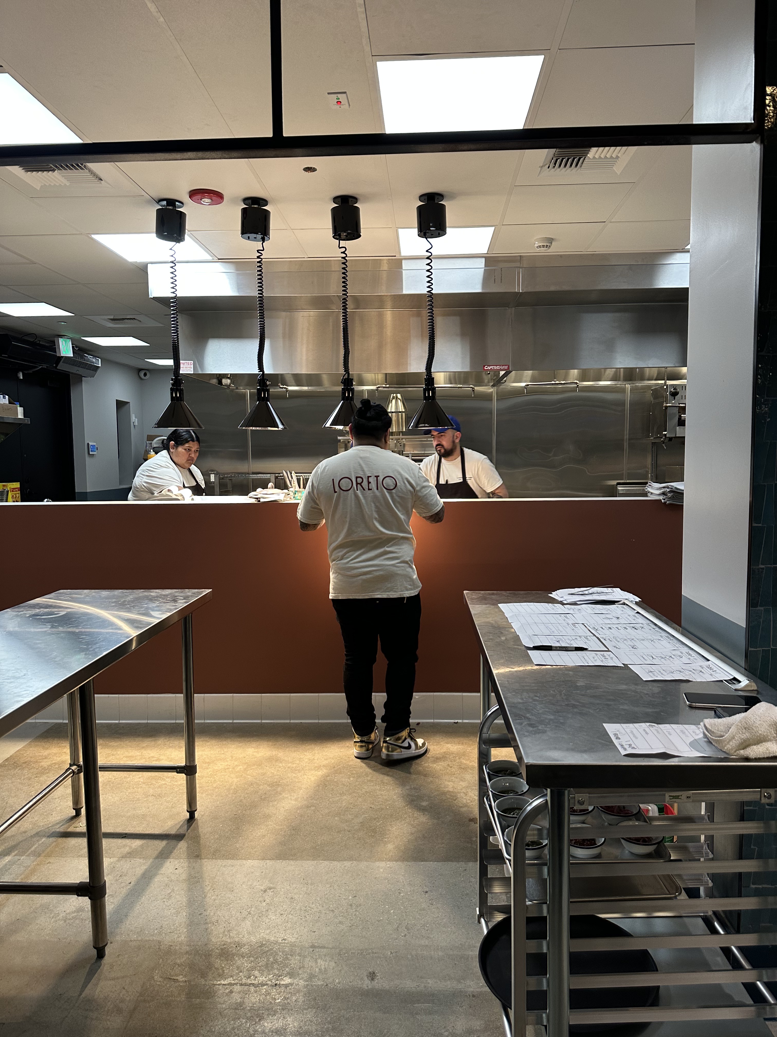 Cooks working the expo pass at Loreto