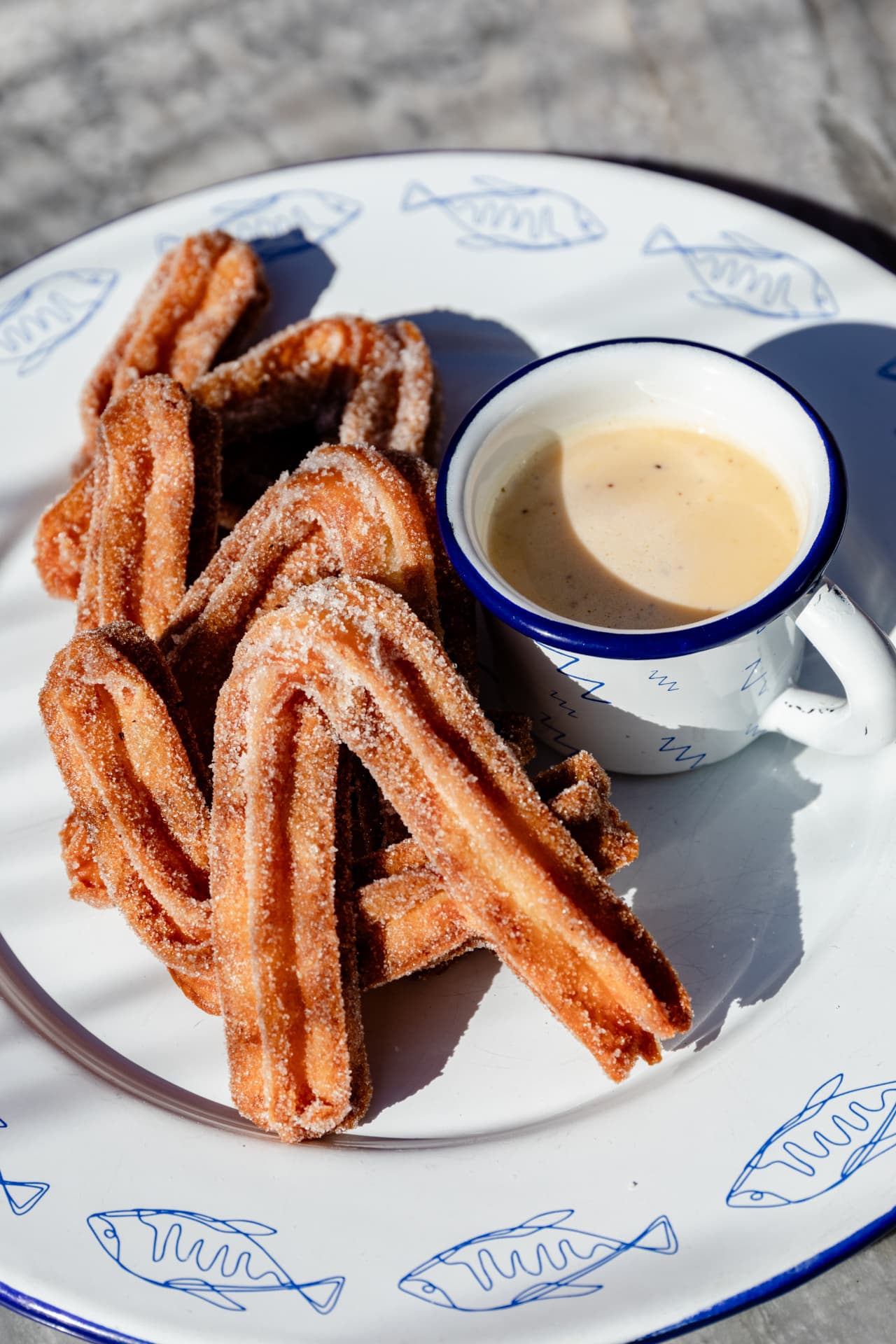 Churros with cajeta dipping cup on fish plateware